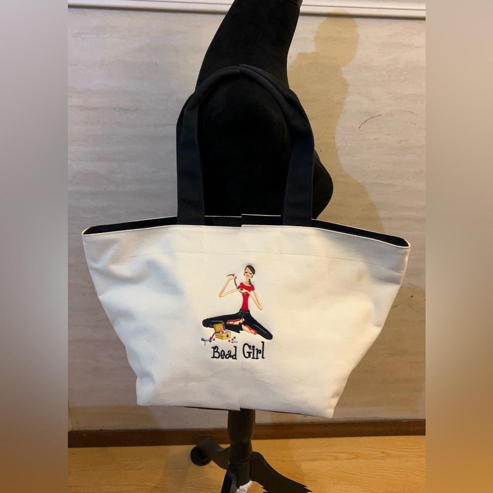 The Girls" collection.
Canvas Tote Bag with black handle